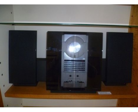 A "Bang & Olufsen" free standing radio/cassette/compact disc player with smoked glass sliding frontage, together with a pair 