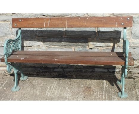 A cast iron ended garden bench, with leaf design, painted green, having teak seat and back planks, 1.43m wide 