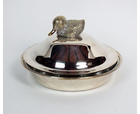 A silver plated circular serving dish, of plain polished form with glass liner, the domed removable cover with cast duck fini