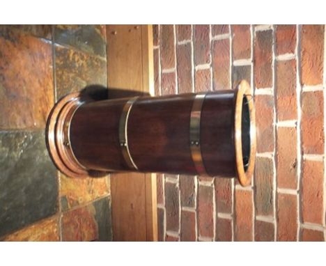 A barrel design oak cylindrical stick stand, circa 1900, with brass hoops, on turned platform, base with removable tin liner,