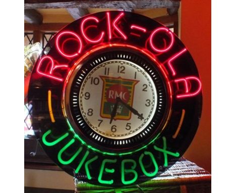 An RMC Rock-ola juke box wall clock, 20th century with rotating inner lens, coloured neon light surround within a black case 