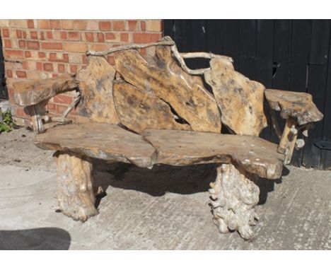 A rustic garden bench, assembled from cross-cut tree sections, on pair of stump supports, 1.64m wide 