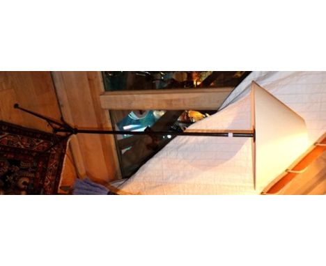 A contemporary metal standard lamp on tripod base, having plain cream shade 