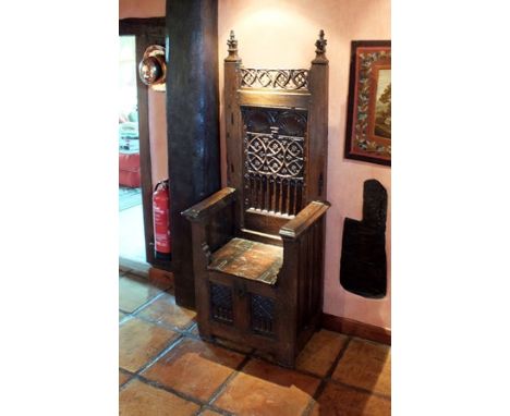 A late 15th/early 16th century Northern French oak Gothic throne chair, the high rectangular back with carved foliate finials