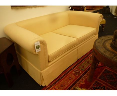 A modern two seater low sofa, covered in a cream trellis pattern material, 168cm wide