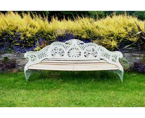 A Victorian cast iron garden bench, of scrolling form with bound reed arms, acanthus leaf crest, fern, rose and pea panels, w