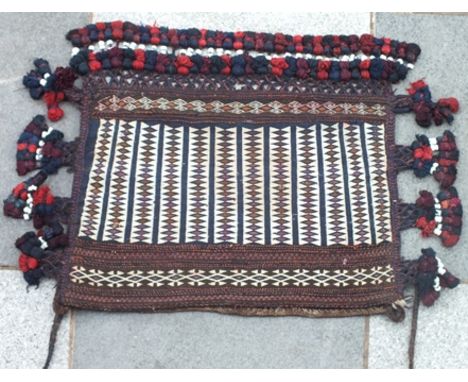 An Afghan Chuval bag, blue ground with cream bands, having running lozenge design, deeply tassel fringed with ceramic beads w