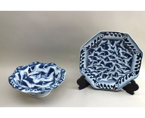A 20th century Japanese blue and white glazed ceramic octagonal charger, decorated with cranes in flight with a wave and flor