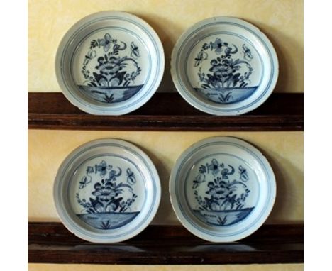Four Bristol blue and white ceramic plates, line borders and flowering plants with insects to centre, 22.5cm diameter illustr