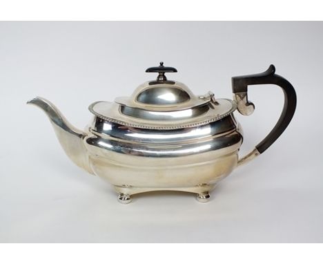 A George V silver teapot, Mappin & Webb, Sheffield 1915, of oval form with gadrooned rim and ebonised handle and finial, rais