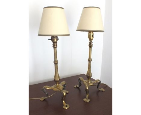 A pair of brass "Pullman" type railway carriage lamps, having hexagonal knopped stems, on arched tripod feet (one with hole t