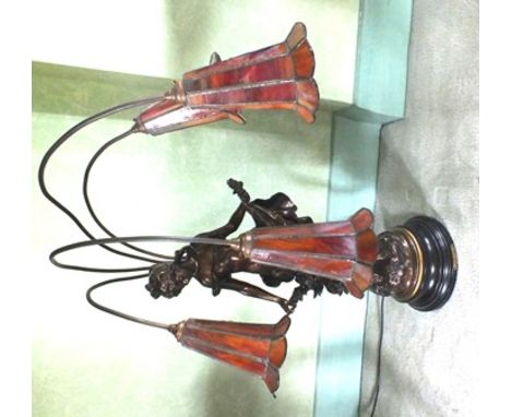 An Art Nouveau design table lamp of bronzed female form, with four light arms as stalks with floral trumpet shades of marbled