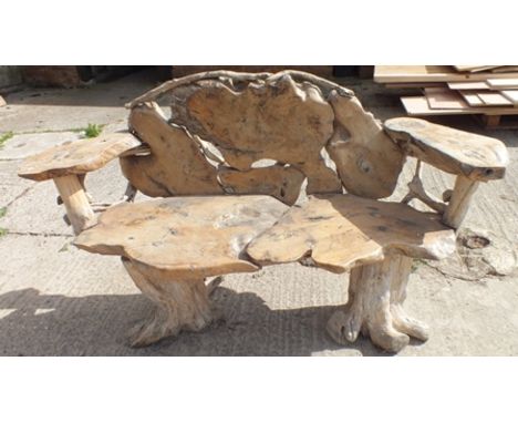 A rustic garden bench, constructed from sections of timber, on tree stump supports, 1.61m wide, 89cm high 
