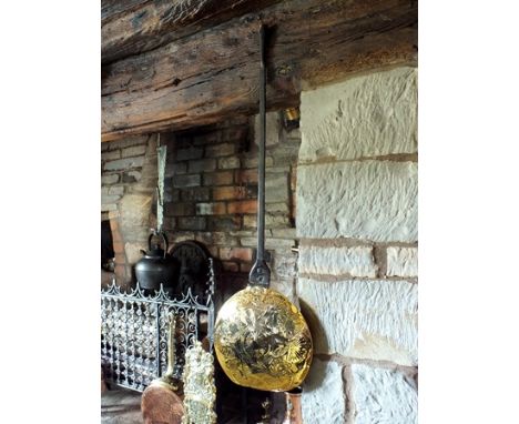 A 17th century warming pan, the brass domed lid embossed with fan medallions and punched six point star, wrought iron handle 