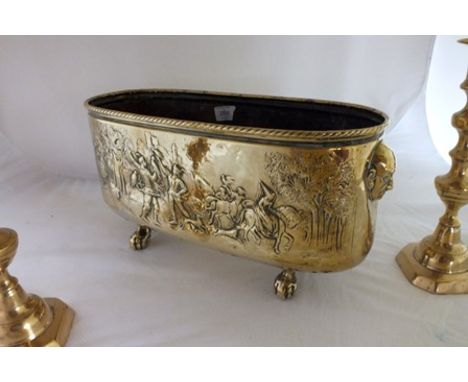 A 19th century embossed brass planter, decorated with Elizabethan hunting scenes, with mask handles, raised on ball and claw 