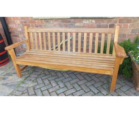 A stained wood garden bench, having slatted back and seat, on squared supports, 1.3m wide 