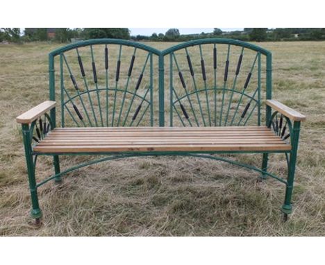 A 20th century cast metal garden bench, having green painted double arched back, bound reed frame with bulrush panels, planke