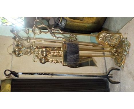 A 19th century design brass fireside companion set, the decorative stand holding a shovel, poker and tongs, with cast ball an
