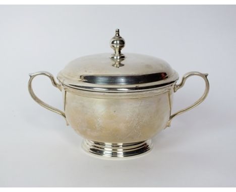 A Tiffany & Co sterling silver two handled sugar bowl and cover, the bowl of plain polished circular form with two scroll han