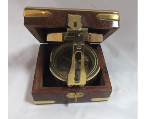 A reproduction brass compass inscribed "Stanley" in brass bound box, with anchor and ship's wheel motif, box 10cm wide 