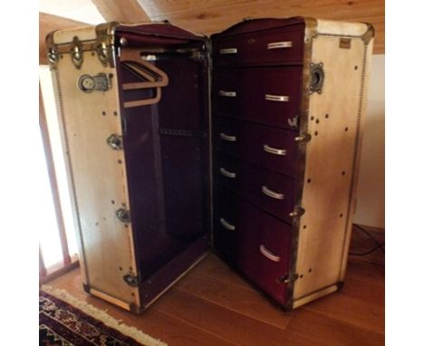An Edwardian vellum cabin trunk, having re-enforced corners and studded, opening on end to reveal one half fitted with five d