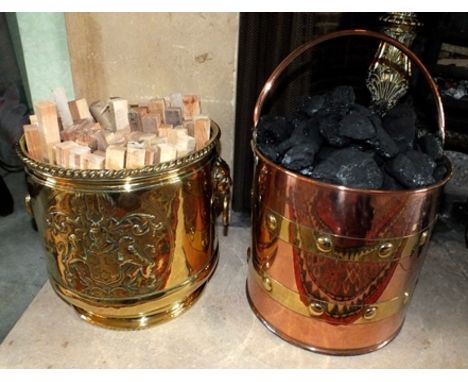 An embossed brass planter with coat of arms decoration and lion ring mask handles, 26cm high, together with a brass banded co