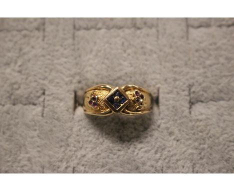 Ladies Continental Yellow metal with polished wire border set with quatrefoils of sapphire and Ruby. 3g total weight Size M 