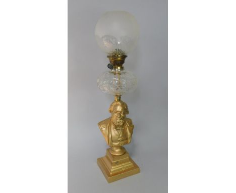 An oil lamp, with cut glass reservoir and Duplex burner supported on a white metal bust of Leon Gambetta after E Guillemier, 