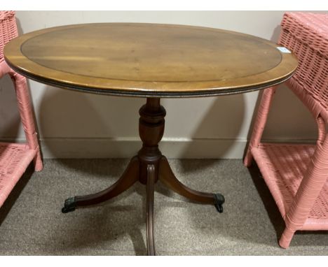 MAHOGANY OVAL OCCASIONAL TABLE, on paw feet, 67cm wide, along with a cream painted oval wall mirror, 84cm wide (2)