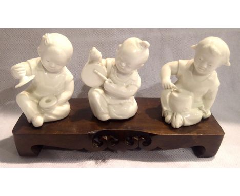 Three Oriental ceramic musician figurines on a wooden base, each H: 11 cm. P&amp;P Group 2 (£18+VAT for the first lot and £3+