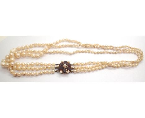 Triple string pearl necklace with a large 9ct gold and garnet clasp, L: 45 cm, 31.0g. P&amp;P Group 1 (£14+VAT for the first 