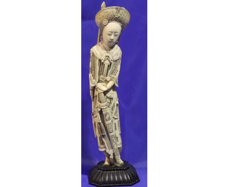 Tall ivory figurine on wooden stand with pierced armour decoration carrying a spear and a quiver, H: 350 mm, not signed but n