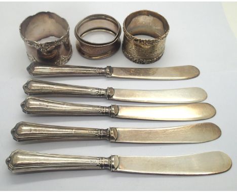 Three silver napkin rings and five silver handled butter knives (7). P&amp;P Group 2 (£18+VAT for the first lot and £3+VAT fo