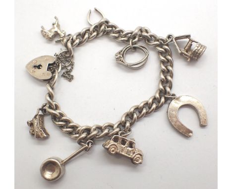 925 silver charm bracelet with eight charms to include car and wishing well, L: 18 cm, 39g. P&amp;P Group 1 (£14+VAT for the 