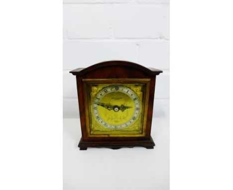 Elliot mahogany cased mantle clock, retailed by Mappin & Webb, with gold dial and cherub spandrels and Roman numerals, on bra