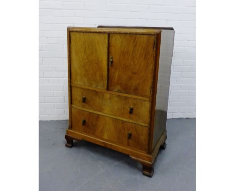 A mahogany ledgeback cabinet, the rectangular top above a pair of cupboard doors opening to reveal shelved interior above two