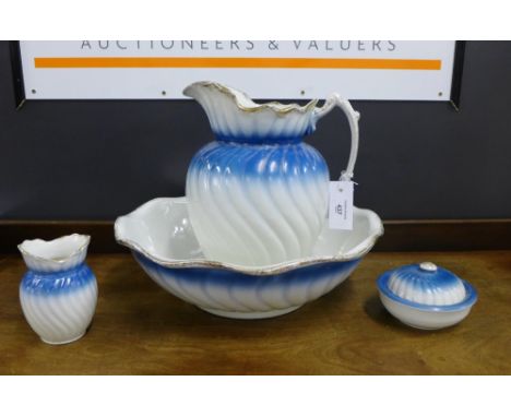 A Staffordshire blue and white pottery toilet set comprising jug and basin, soap dish and small vase (4) 