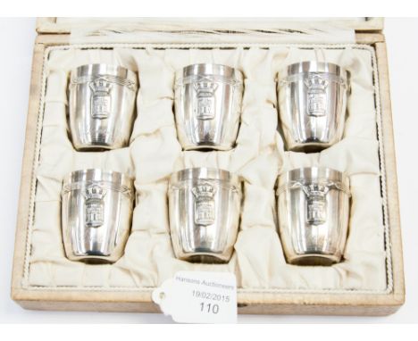 An early 20th century boxed set of six 'Lens' armorial silver white metal tots, each bearing a crowned shield depicting a cas