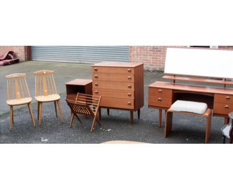 A late 20th Century teak effect bedroom suite, comprising dressing table and stool, chest of drawers, bedside cabinet; a pair