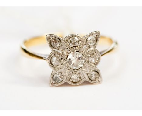 An Edwardian diamond ring, with platinum shaped square millegrain setting and central round cut stone, surrounded by eight fu