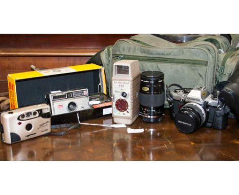 A collection of vintage cameras, including Olympus OM-10, with lenses, Kodak Instamatic 100 boxed, Bell Howell 8 mm 