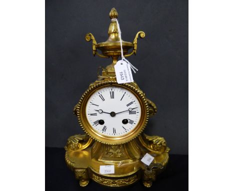 A 19th century French ormolu mounted eight day mantle clock, the top with an urn shaped finial, the face having a white ename