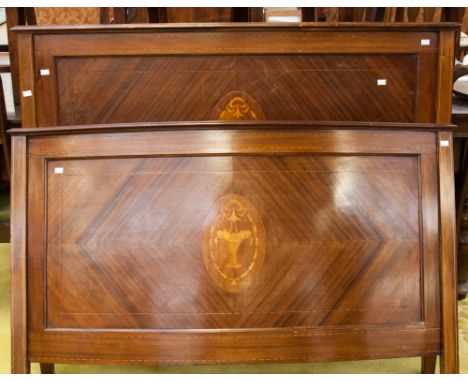 An Edwardian mahogany bedstead, inlaid with boxwood stringing and having a central panel of marquetry, complete with iron fra