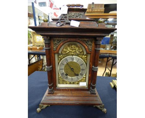 A late Victorian oak eight day bracket clock, the face with a silvered chapter ring and black Roman numerals, the case with a
