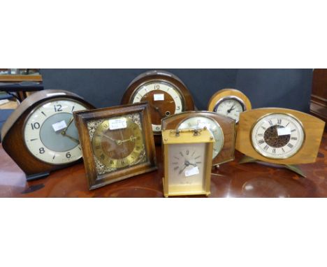 A collection of assorted clocks, comprising a Smiths mantle clock, a similar mantle clock, a small carriage quartz clock, a 1