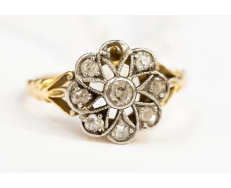 A late Victorian diamond cluster ring, with seven old cut diamonds (one missing) arranged around a central diamond in openwor