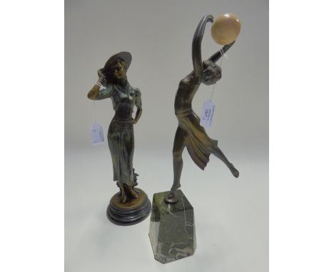 An Art Deco style spelter figure of a lady, playing with a ball, raised on a marble base, plus a bronzed figure of a lady wea