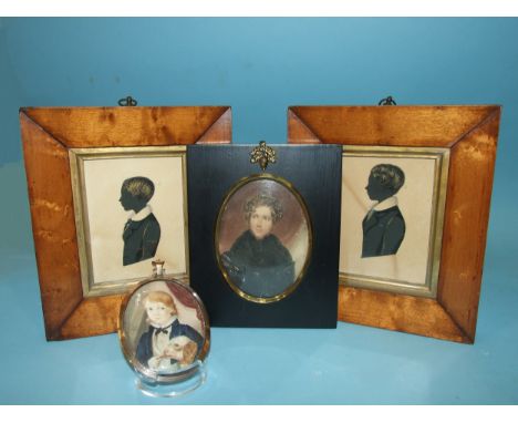 A watercolour miniature portrait on paper of a young man in a black tunic, oval, 10 x 7.5cm, two 19th century silhouettes, ea