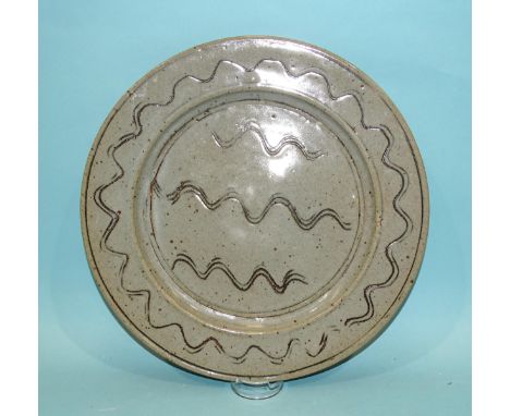 Ray Finch, Winchcombe Pottery, a circular glazed charger decorated with incised wavy lines, 32cm diameter, impressed mark ben