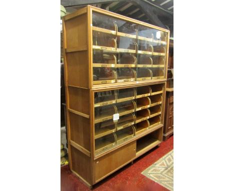 A vintage oak faced haberdashery cabinet of full height (in two sections) enclosed by sliding glass doors, sliding timber doo